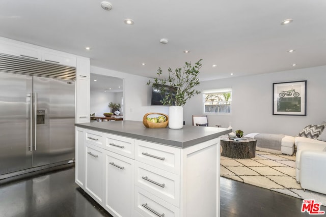 kitchen featuring white cabinetry, dark hardwood / wood-style flooring, and stainless steel built in refrigerator