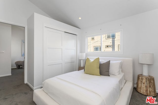 bedroom with carpet flooring, a closet, and vaulted ceiling