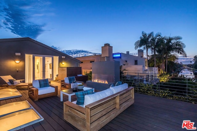 deck at dusk featuring an outdoor hangout area