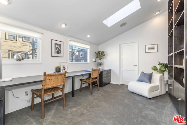 office space featuring dark carpet and vaulted ceiling with skylight