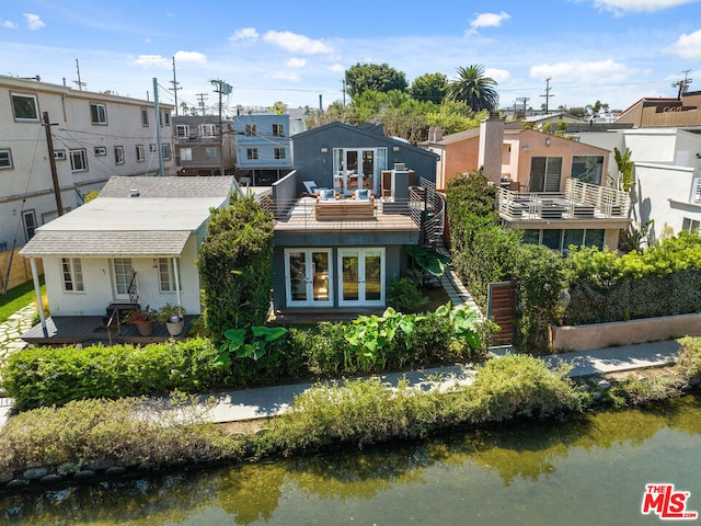 rear view of house with a water view and a balcony