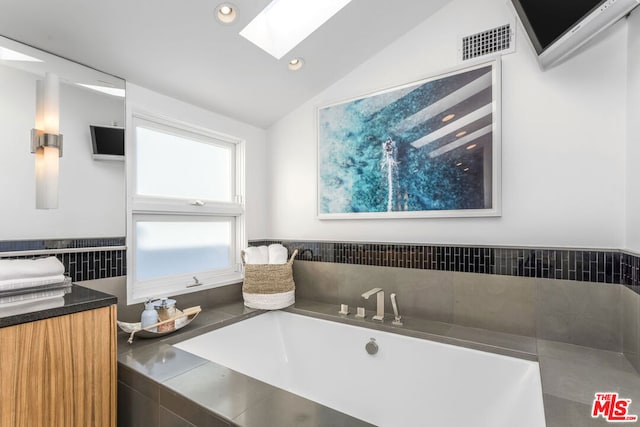 bathroom featuring vaulted ceiling with skylight