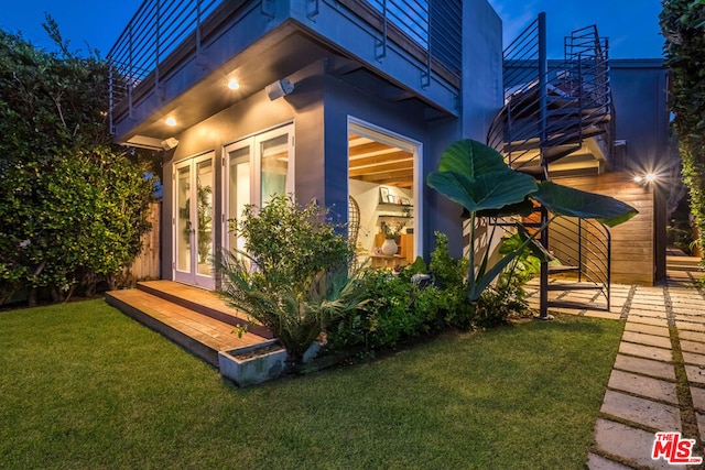 view of property exterior with a lawn and a balcony