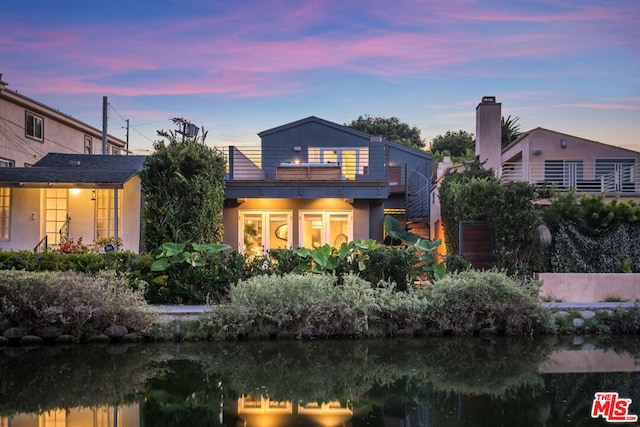 back house at dusk with a water view