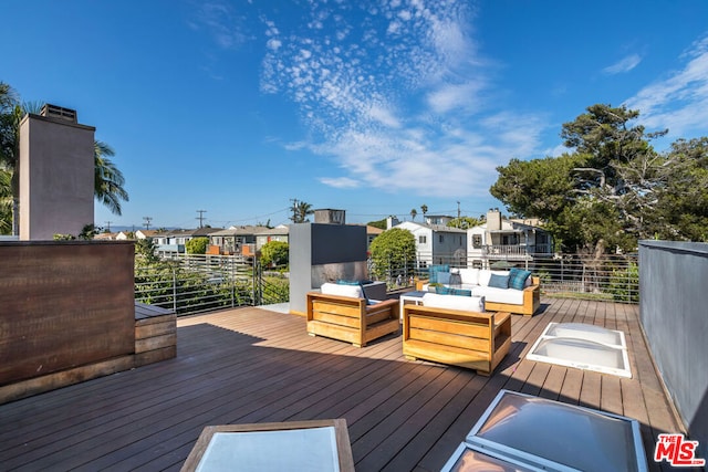 wooden terrace with an outdoor living space and grilling area