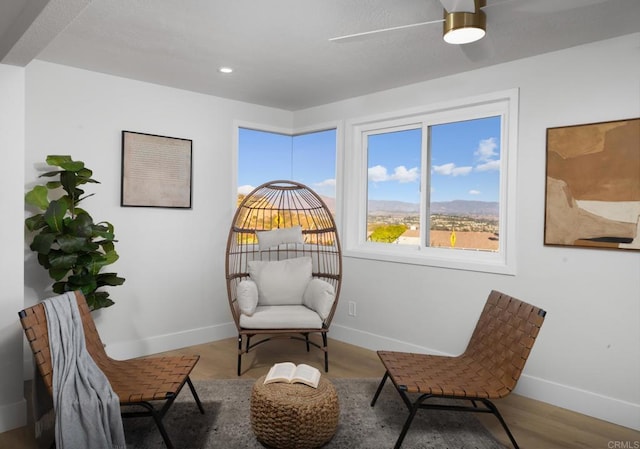 sitting room with wood-type flooring and ceiling fan