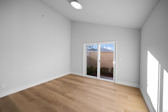 unfurnished room featuring light hardwood / wood-style flooring and lofted ceiling