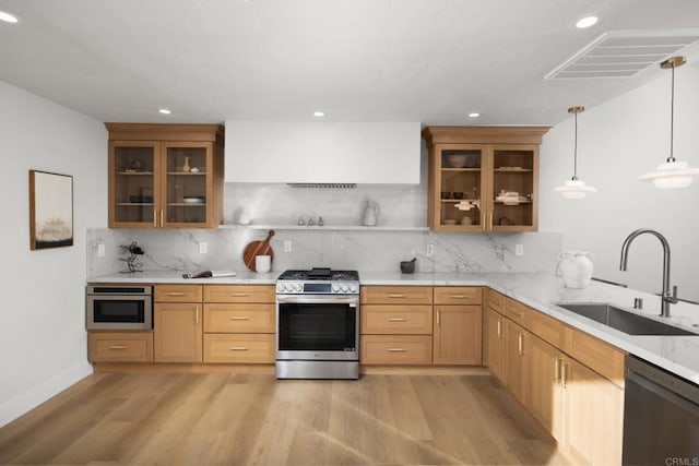 kitchen with backsplash, sink, hanging light fixtures, gas range, and dishwashing machine