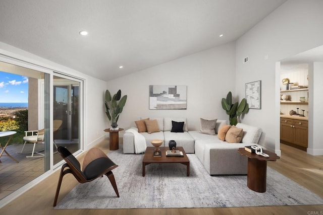 living room with light hardwood / wood-style flooring and vaulted ceiling