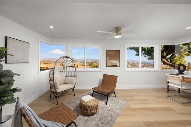 sitting room with ceiling fan and light hardwood / wood-style flooring