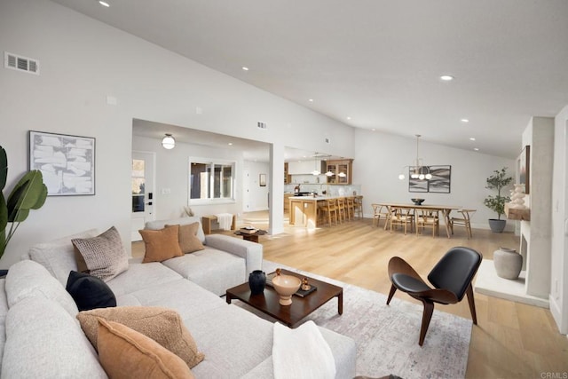 living room featuring light hardwood / wood-style floors and high vaulted ceiling