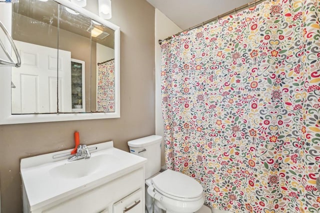 bathroom with a shower with shower curtain, vanity, and toilet