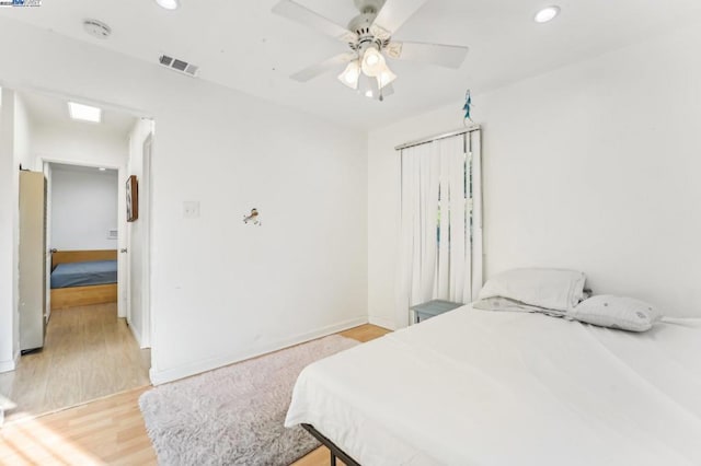 bedroom with fridge, ceiling fan, and light hardwood / wood-style floors