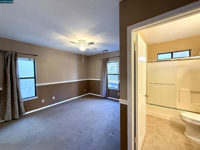 empty room with ceiling fan and light tile patterned floors