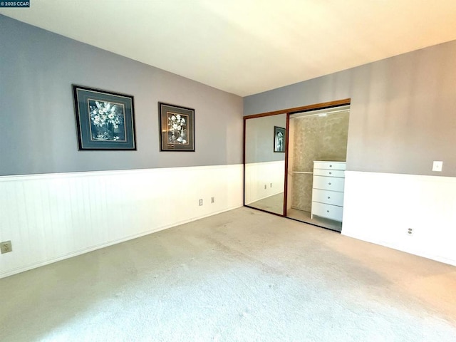 unfurnished bedroom featuring a closet and light colored carpet