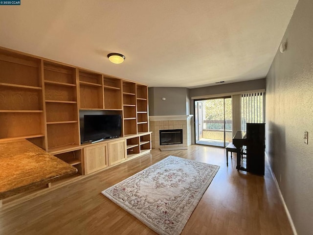 living room featuring a tile fireplace and hardwood / wood-style floors