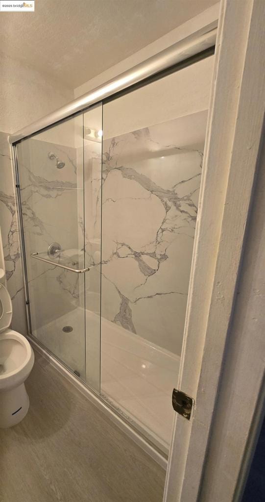 bathroom featuring hardwood / wood-style floors and walk in shower