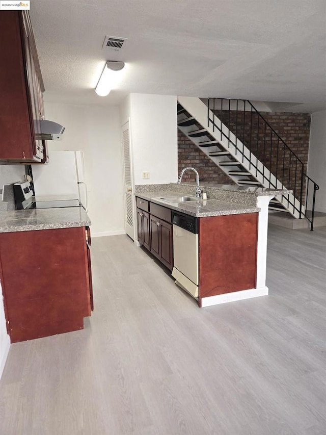 kitchen with a textured ceiling, dishwasher, light wood-type flooring, and sink