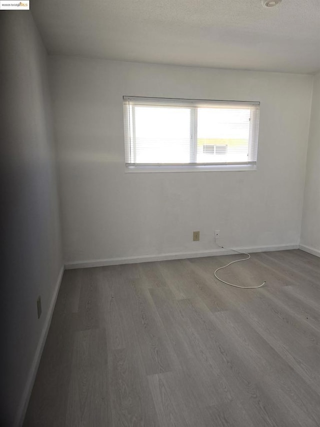 unfurnished room featuring hardwood / wood-style floors and a wealth of natural light