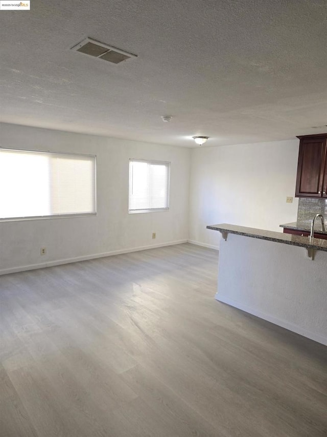 spare room with a textured ceiling, hardwood / wood-style flooring, and sink