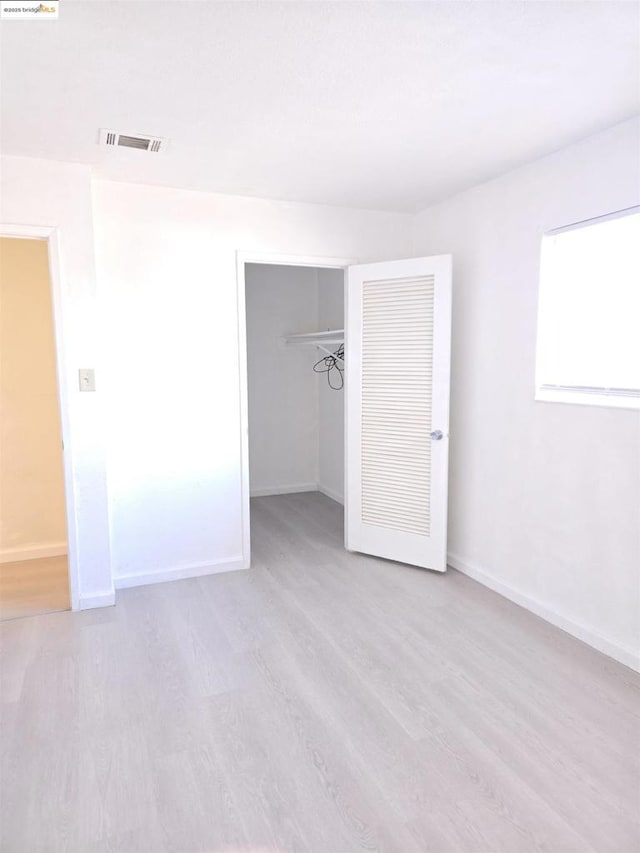 unfurnished bedroom with light hardwood / wood-style floors and a closet