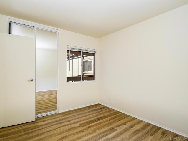 unfurnished bedroom featuring a closet and hardwood / wood-style flooring