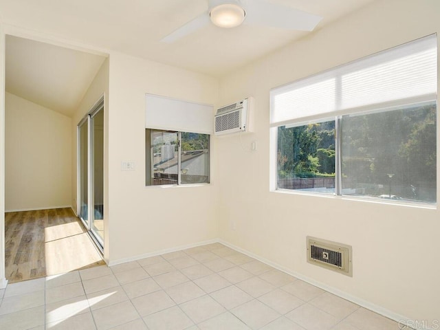 empty room with ceiling fan, light tile patterned flooring, and a wall mounted AC