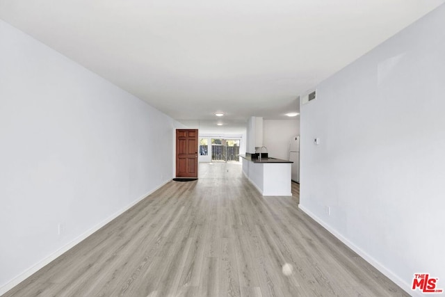 unfurnished living room featuring light hardwood / wood-style flooring and sink