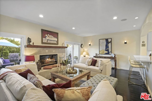 living room featuring dark wood-type flooring and a high end fireplace