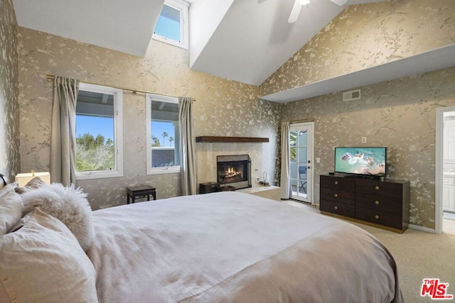 bedroom with ceiling fan, light colored carpet, connected bathroom, and high vaulted ceiling