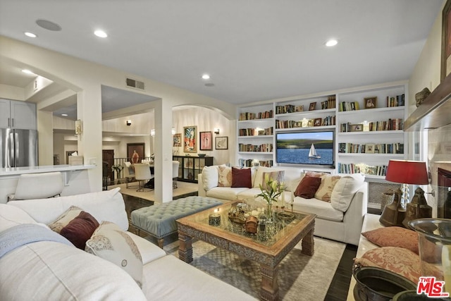 living room featuring built in features and light hardwood / wood-style flooring