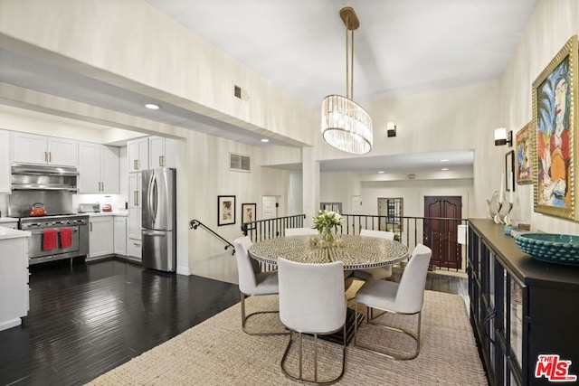 dining room with dark hardwood / wood-style floors and an inviting chandelier