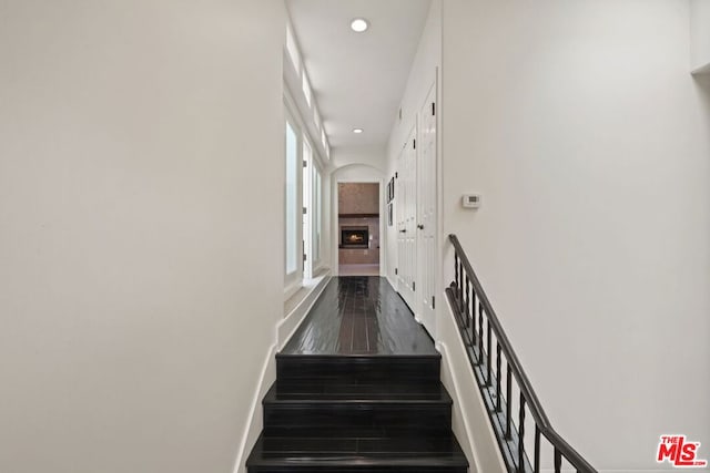 stairway with plenty of natural light and hardwood / wood-style flooring