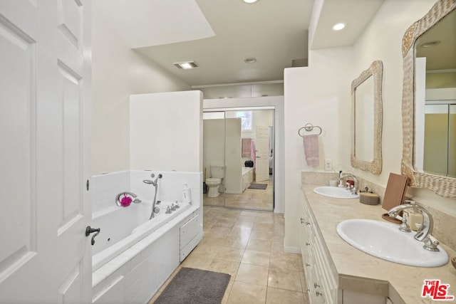 bathroom featuring toilet, tile patterned floors, tiled bath, and vanity