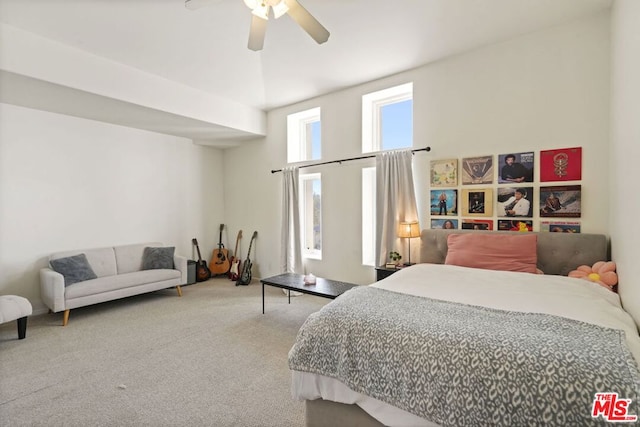 carpeted bedroom featuring ceiling fan and a towering ceiling