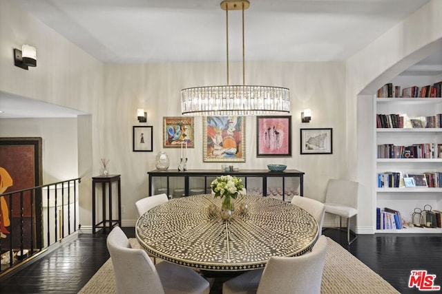 dining area with a chandelier, built in features, and dark hardwood / wood-style floors