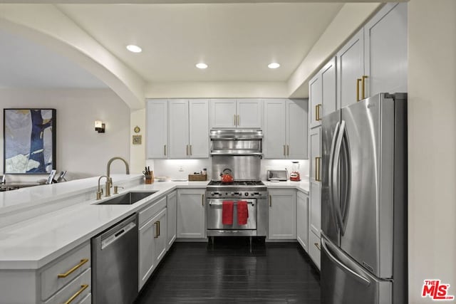 kitchen with white cabinetry, stainless steel appliances, kitchen peninsula, and sink