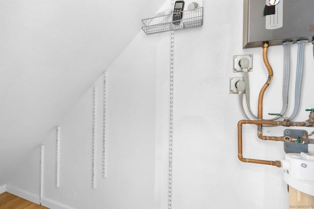 walk in closet featuring water heater and hardwood / wood-style floors