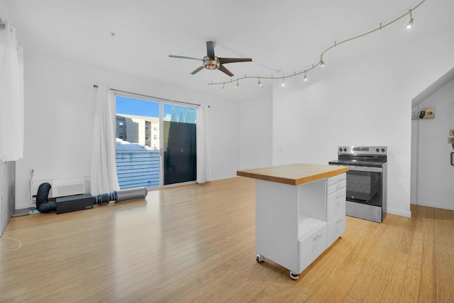 kitchen with white cabinetry, ceiling fan, a center island, and stainless steel range with electric cooktop