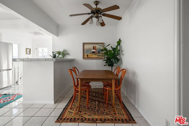 tiled dining room featuring ceiling fan and ornamental molding