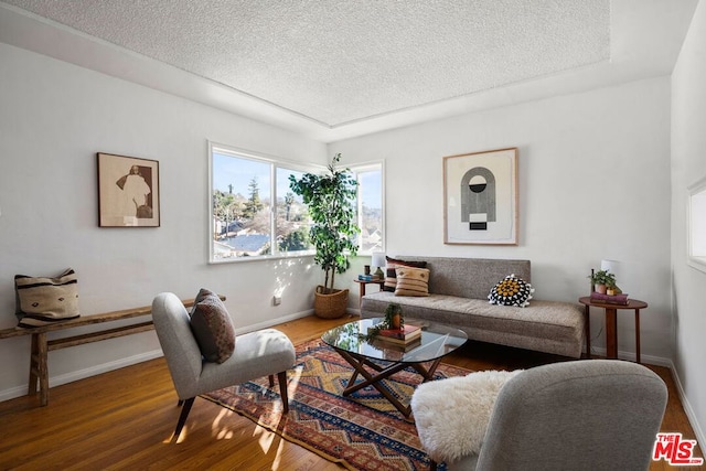 living room with a textured ceiling and hardwood / wood-style flooring