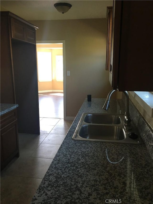 kitchen with sink, dark brown cabinetry, and tile patterned floors