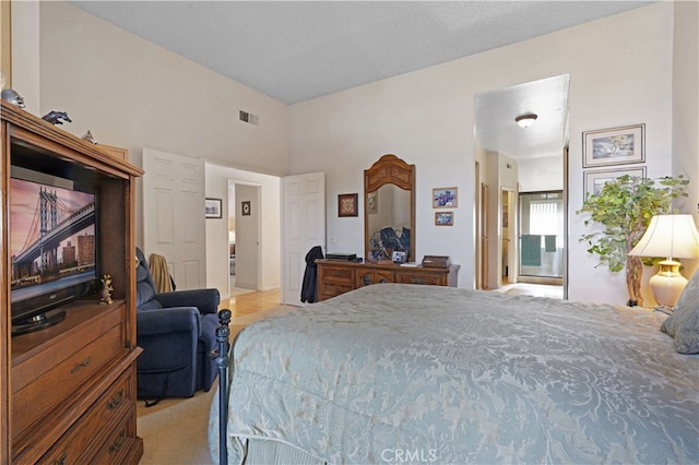 bedroom with light carpet and connected bathroom