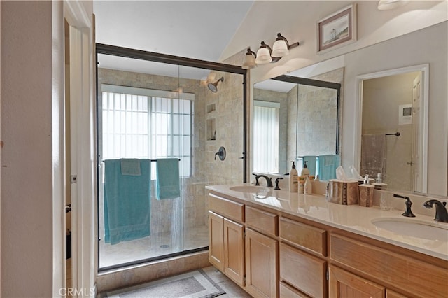 bathroom featuring lofted ceiling, a shower with shower door, and vanity