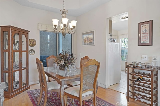 dining area featuring a notable chandelier and light wood-type flooring