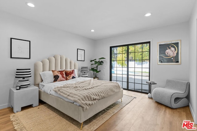 bedroom featuring access to exterior and hardwood / wood-style flooring