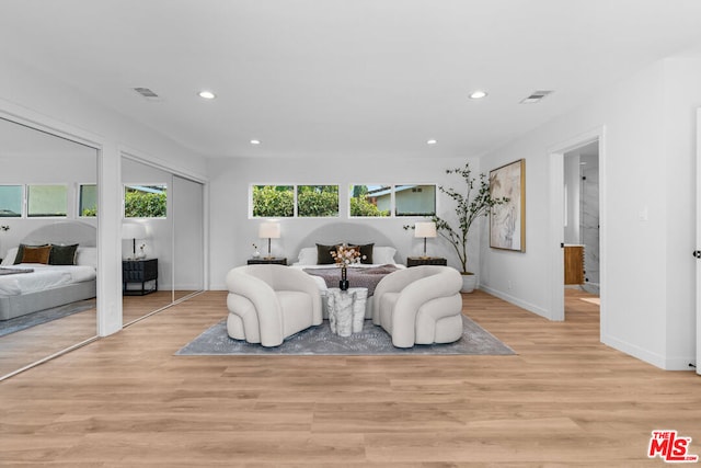 bedroom featuring light hardwood / wood-style floors and multiple closets