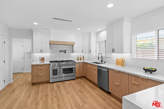 kitchen featuring white cabinetry, sink, stainless steel appliances, and plenty of natural light