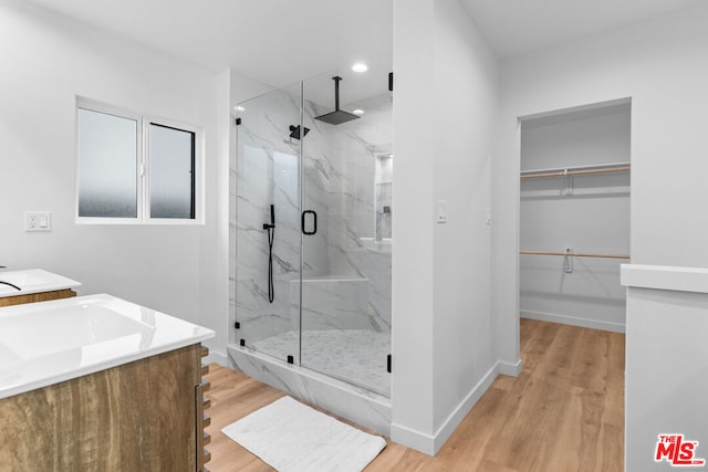 bathroom featuring vanity, wood-type flooring, and a shower with shower door