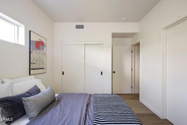 bedroom featuring dark hardwood / wood-style floors and a closet